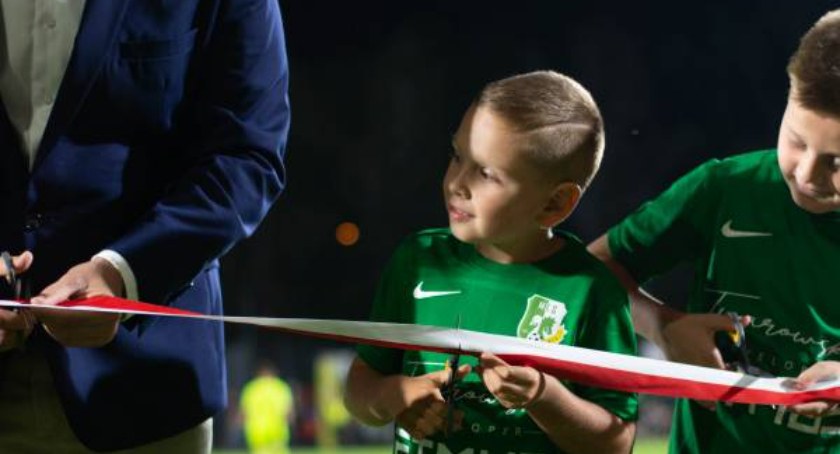 Przedstawiciele młodych piłkarzy przecinają wstęgę na otwarcie stadionu w Białej Podlaskiej